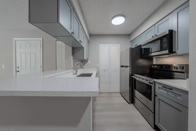 a kitchen with stainless steel appliances a stove microwave and sink