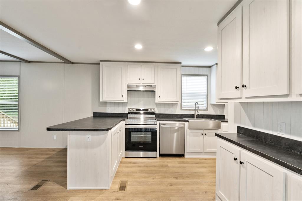 125 Neches Mabank, TX 75156 - Photo 11 of 23 a kitchen with stainless steel appliances granite countertop a stove a sink and white cabinets