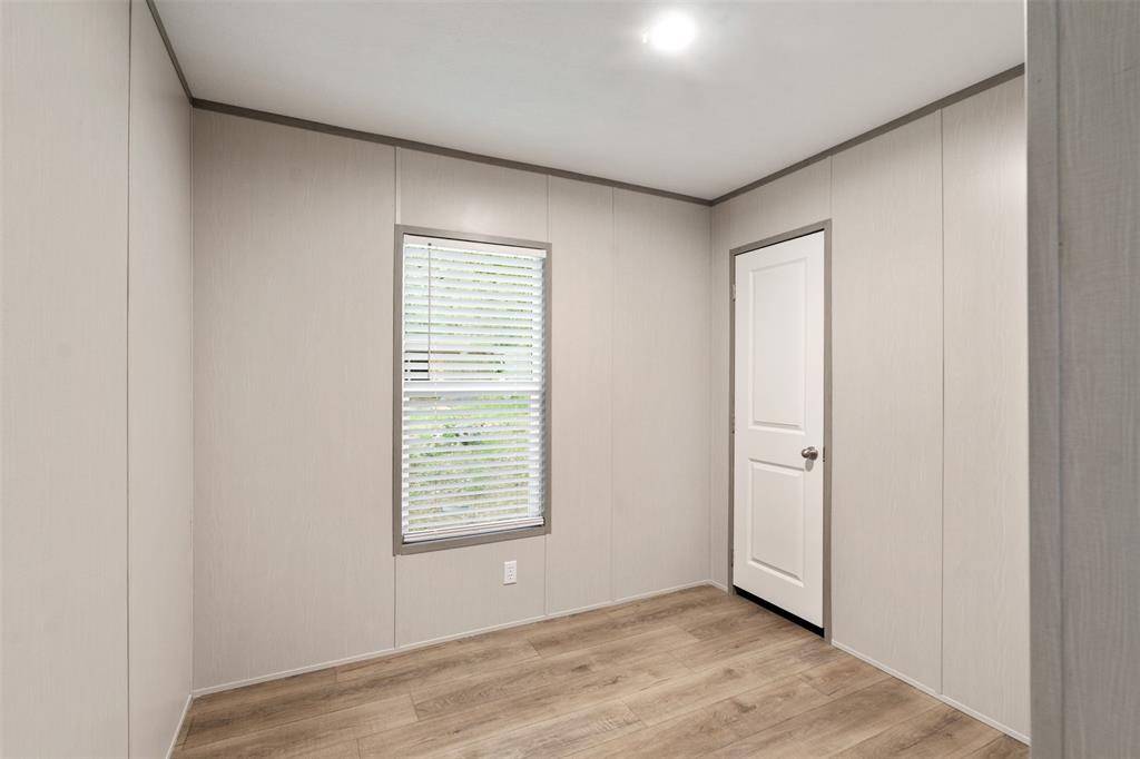 125 Neches Mabank, TX 75156 - Photo 18 of 23 an empty room with wooden floor and windows