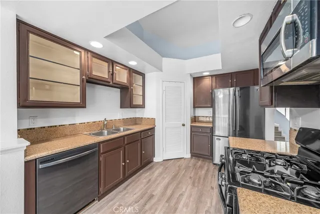 a kitchen with stainless steel appliances granite countertop a sink stove and refrigerator