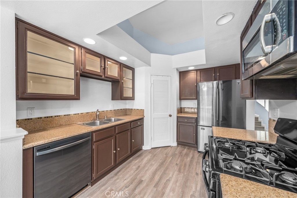 4900 North Grand Avenue, Unit 104 Covina, CA 91724 - Photo 12 of 27 a kitchen with stainless steel appliances granite countertop a sink stove and refrigerator