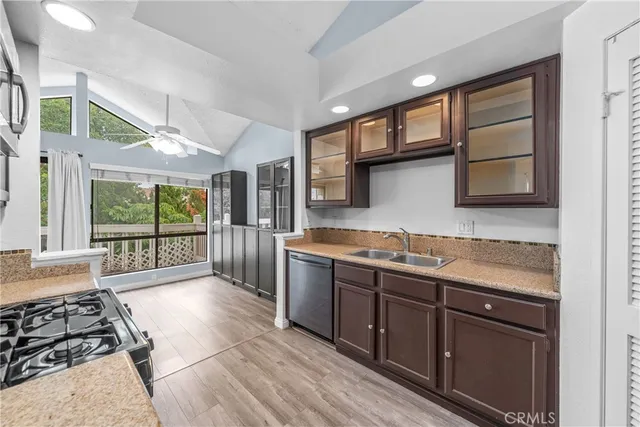 a large kitchen with stainless steel appliances granite countertop a stove a sink and a microwave