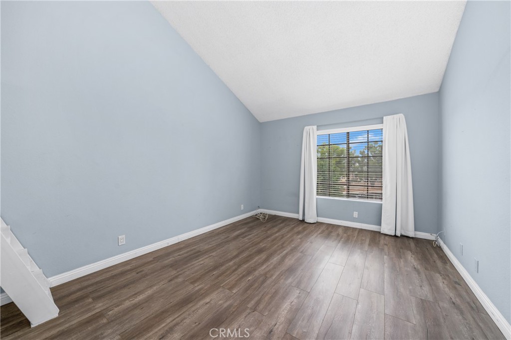 4900 North Grand Avenue, Unit 104 Covina, CA 91724 - Photo 22 of 27 an empty room with wooden floor and windows