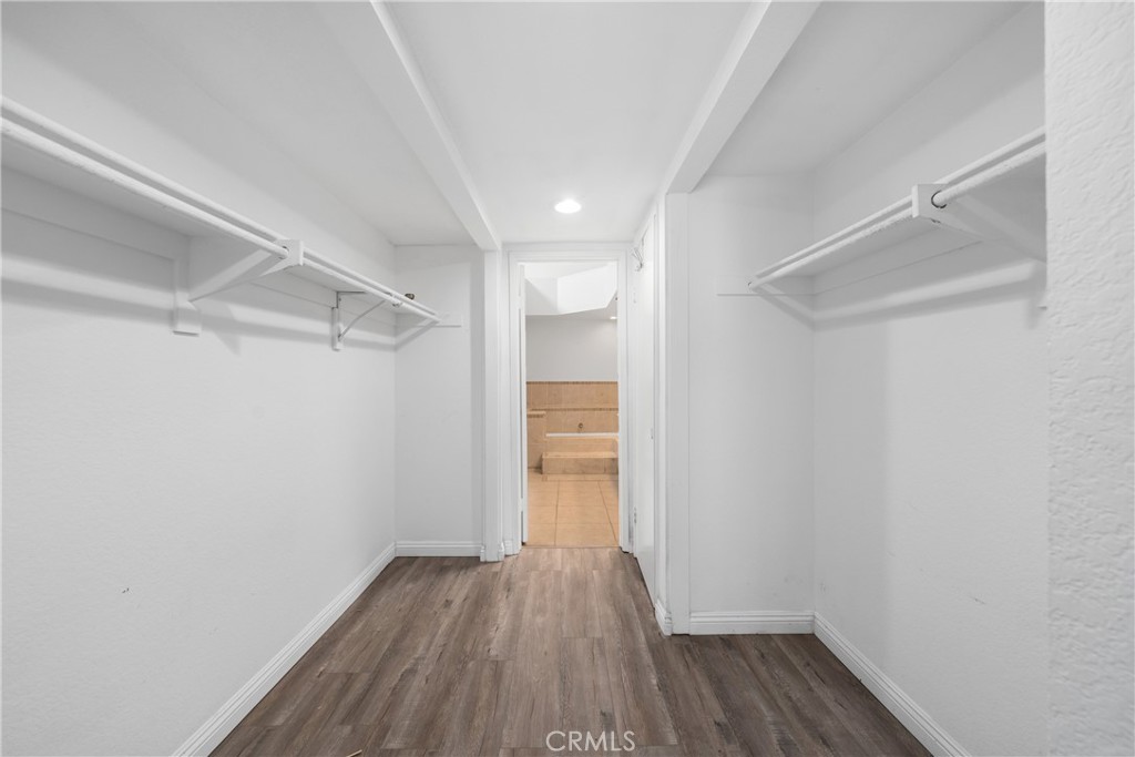 4900 North Grand Avenue, Unit 104 Covina, CA 91724 - Photo 25 of 27 a view of a room with wooden floor and white walls