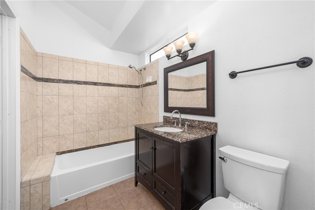 4900 North Grand Avenue, Unit 104 Covina, CA 91724 - Photo 27 of 27 a bathroom with a granite countertop sink toilet and shower