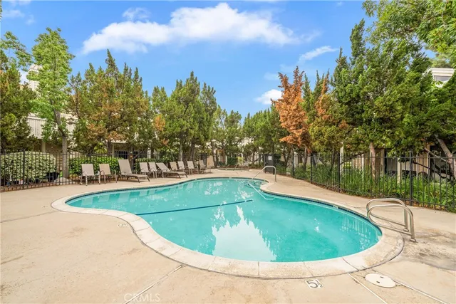 a view of a swimming pool and trees in the background