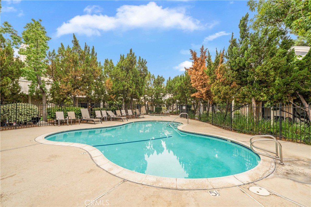 4900 North Grand Avenue, Unit 104 Covina, CA 91724 - Photo 6 of 27 a view of a swimming pool and trees in the background