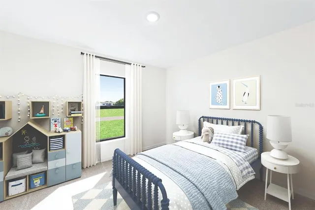 a bedroom with a bed and a lamp on dresser