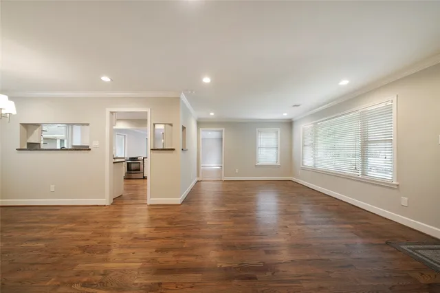 a view of a room with wooden floor chandelier and windows