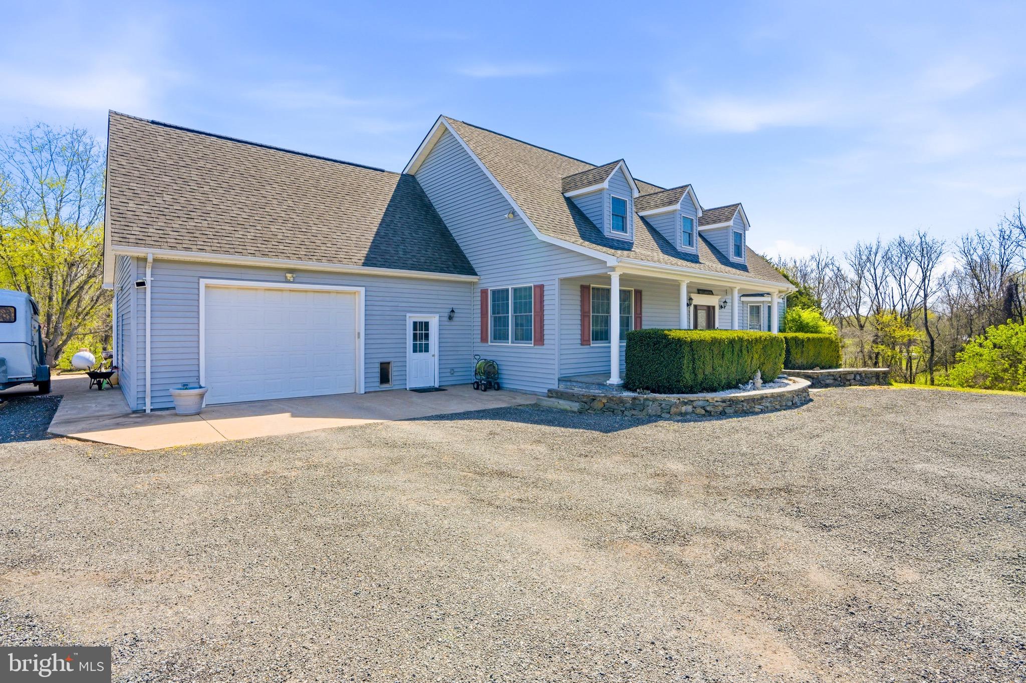 9571 Foxville Road Warrenton, VA 20186 - Photo 7 of 20 a front view of a house with a garden and yard