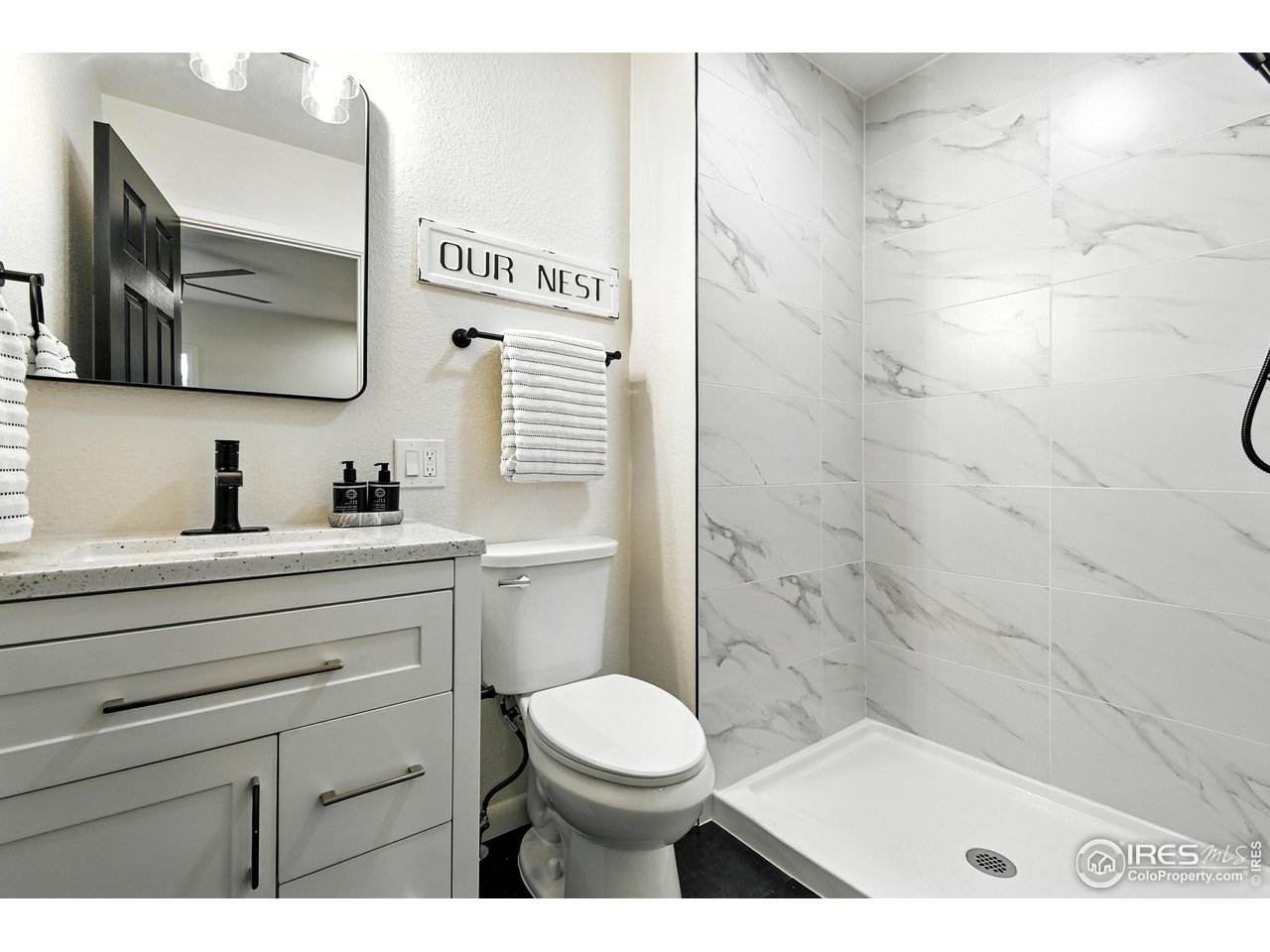 24149 County Road 70 Eaton, CO 80615 - Photo 22 of 40 a bathroom with a toilet a sink a mirror and vanity