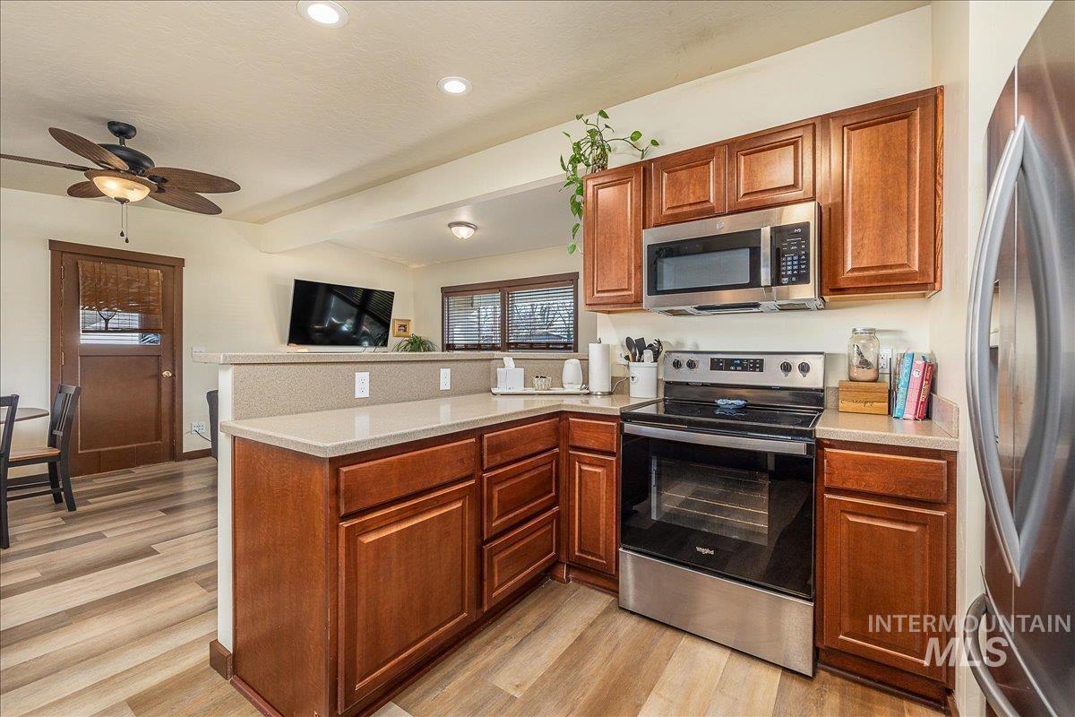 1910 Lemhi Street Boise, ID 83705 - Photo 22 of 41 Kitchen with a peninsula, stainless steel appliances, ceiling fan, wood finish cabinetry, and light wood-type flooring