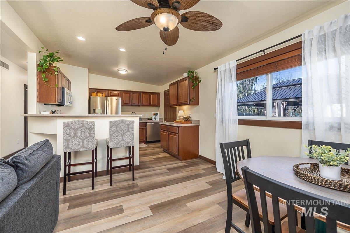 1910 Lemhi Street Boise, ID 83705 - Photo 6 of 41 Kitchen featuring wood finish cabinets, ceiling fan, a breakfast bar area, lofted ceiling, and light wood-style flooring