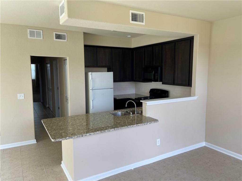 1420 Nevarez Kyle, TX 78640 - Photo 2 of 9 An inviting kitchen features a breakfast bar, ample cabinetry, and modern appliances.
