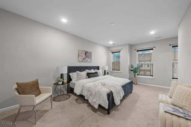 a spacious bedroom with a bed and a chair