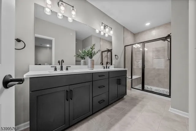 a bathroom with a double vanity sink a large mirror and shower