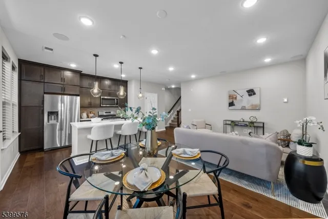 a dining room with furniture a table and kitchen view