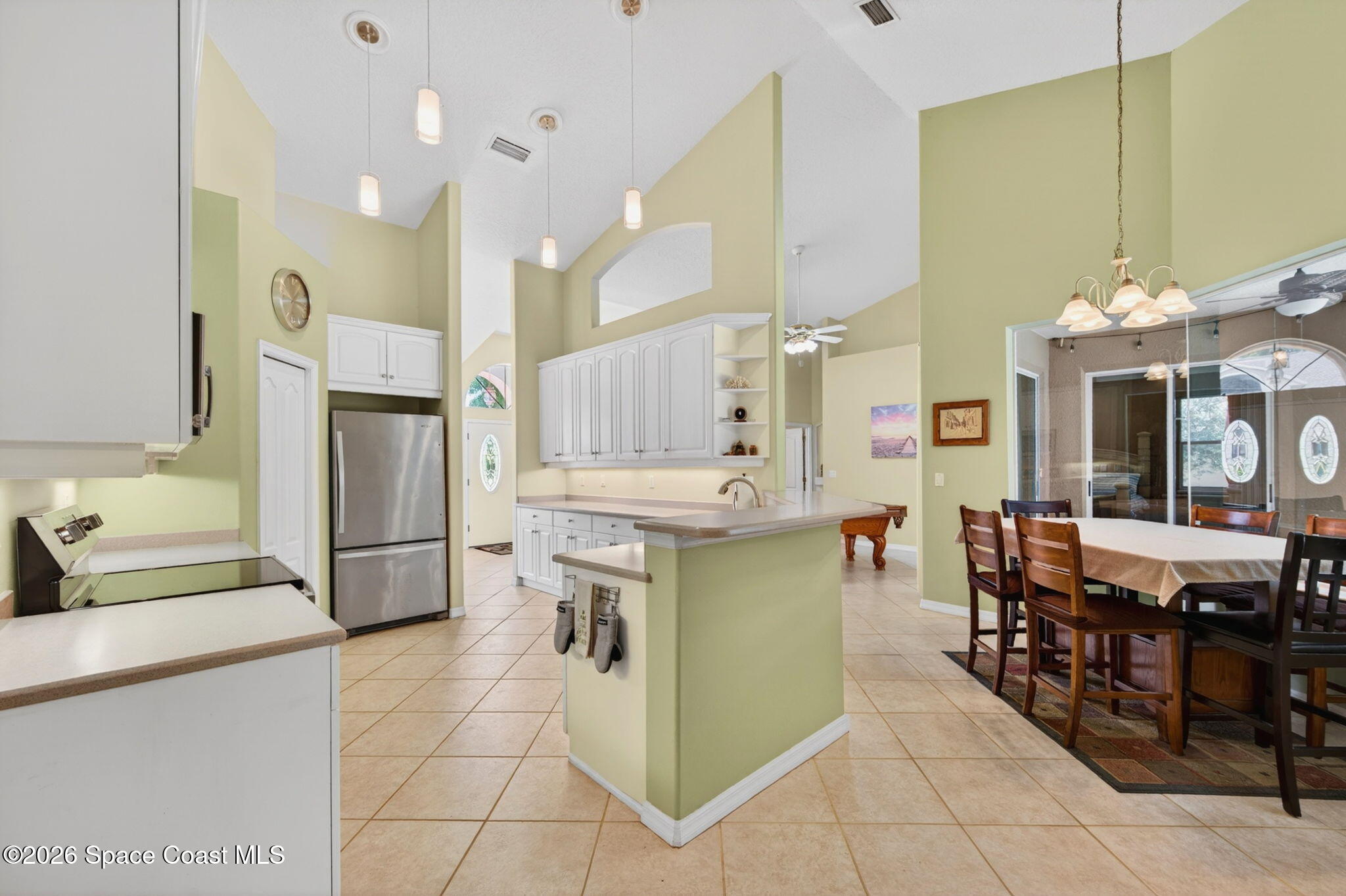 440 Mohawk Trail Merritt Island, FL 32953 - Photo 17 of 86 a kitchen with stainless steel appliances kitchen island granite countertop dining table chairs cabinets and a sink