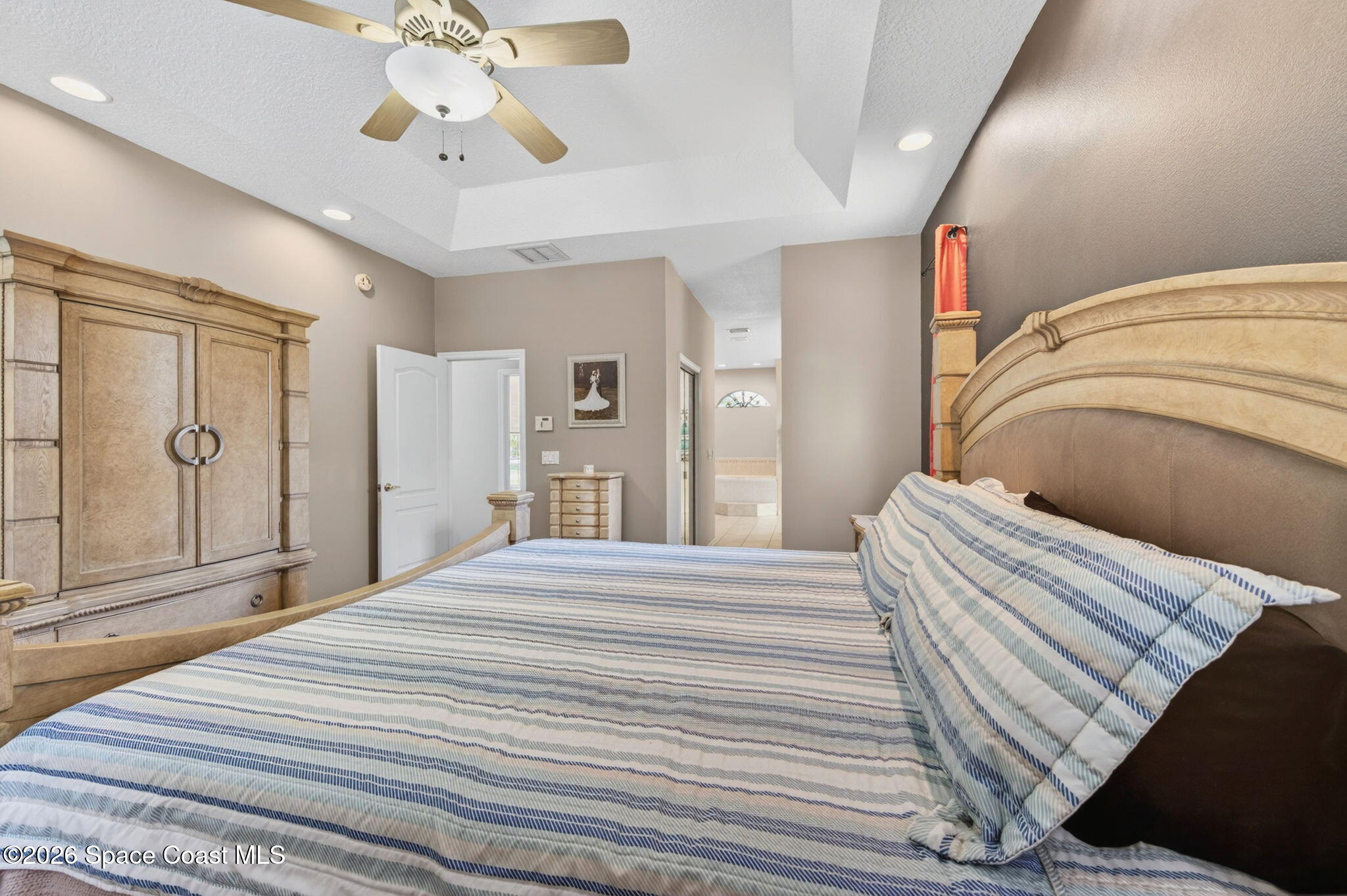 440 Mohawk Trail Merritt Island, FL 32953 - Photo 28 of 86 a bedroom with a bed and a chandelier