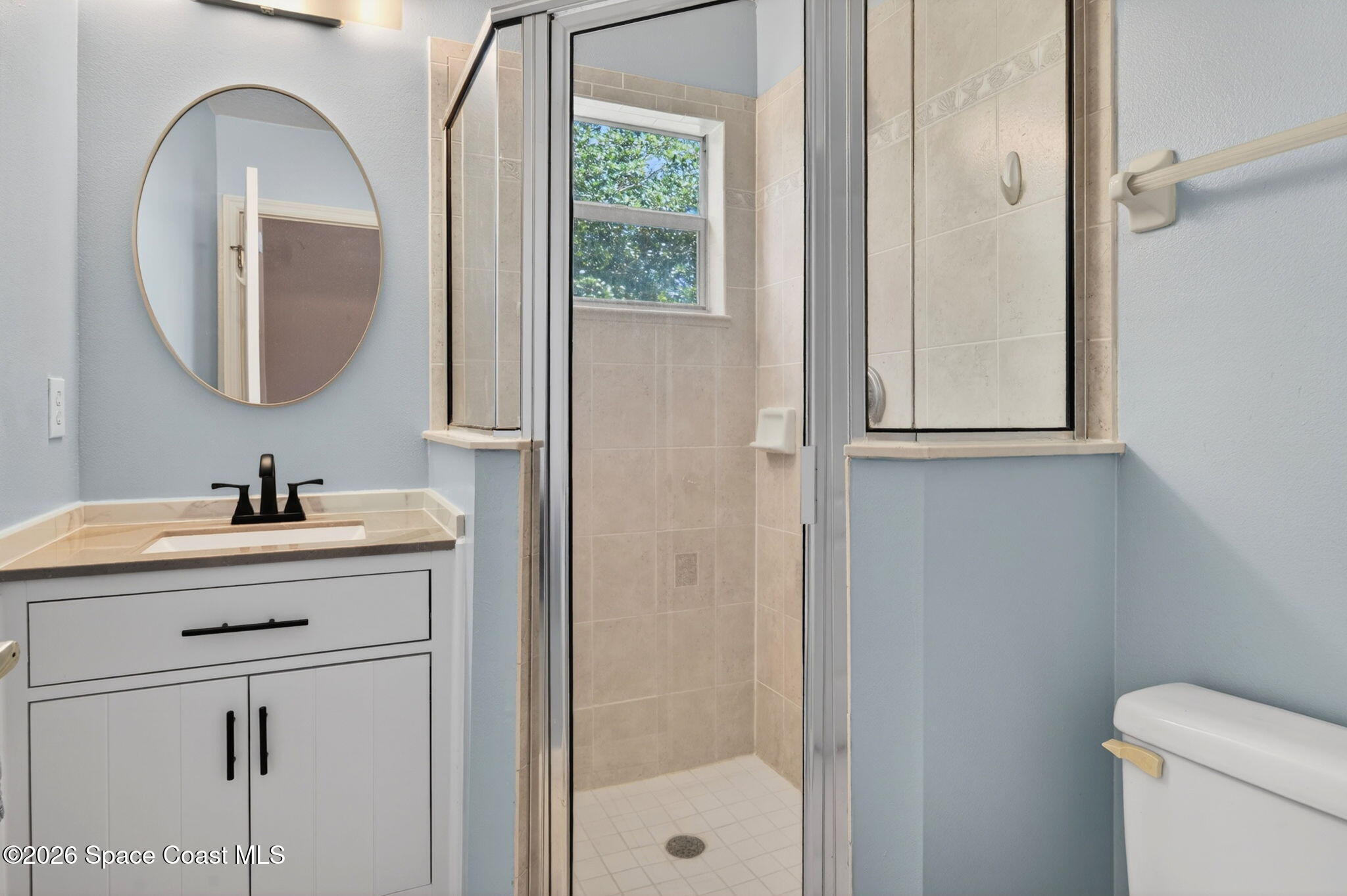 440 Mohawk Trail Merritt Island, FL 32953 - Photo 41 of 86 a bathroom with a sink a mirror a vanity and a shower