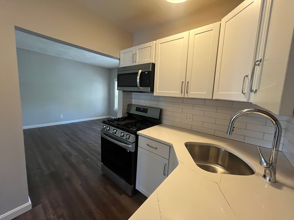 268 River Street, Unit 2 Waltham, MA 02453 - Photo 2 of 9 a kitchen with a sink stove top oven and cabinets