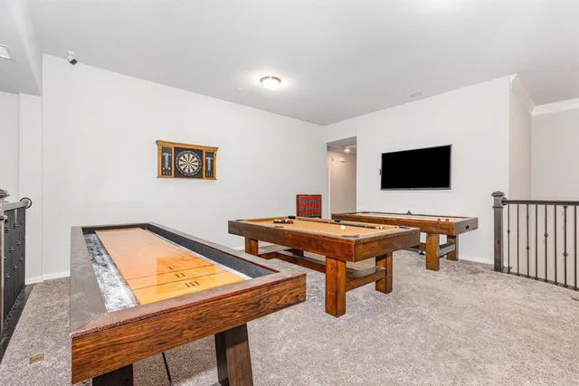 a living room with furniture pool table and a flat screen tv