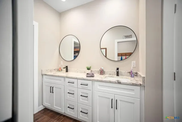 a bathroom with a double vanity sink and a mirror