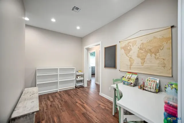 a view of a room with wooden floor and furniture