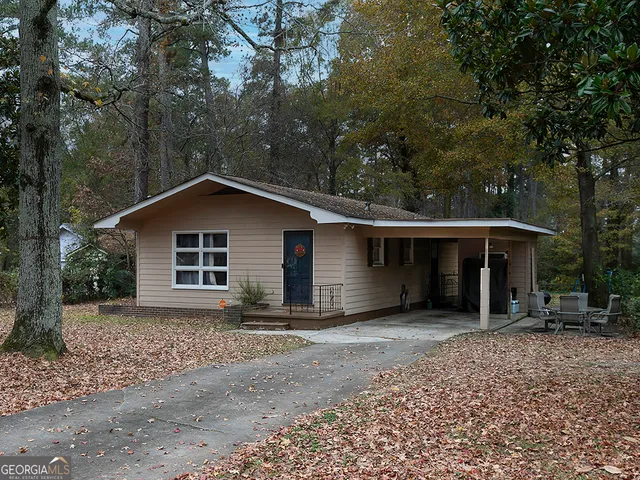 a view of a house with a yard and large tree