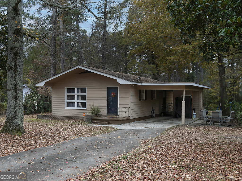 a view of a house with a yard and large tree