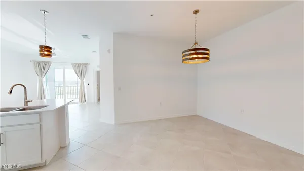a kitchen with stainless steel appliances a sink a stove a dining table and chairs