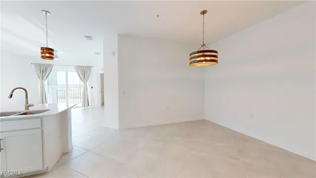 a kitchen with stainless steel appliances a sink a stove a dining table and chairs