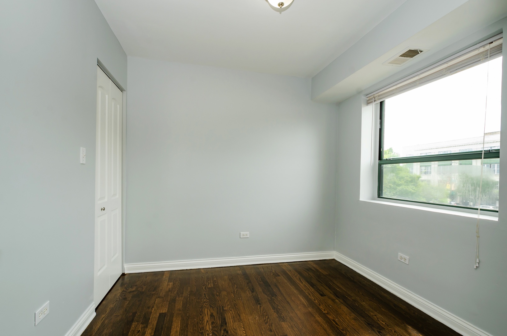 7616 North Marshfield Avenue, Unit 302 Chicago, IL 60626 - Photo 7 of 10 an empty room with wooden floor and windows