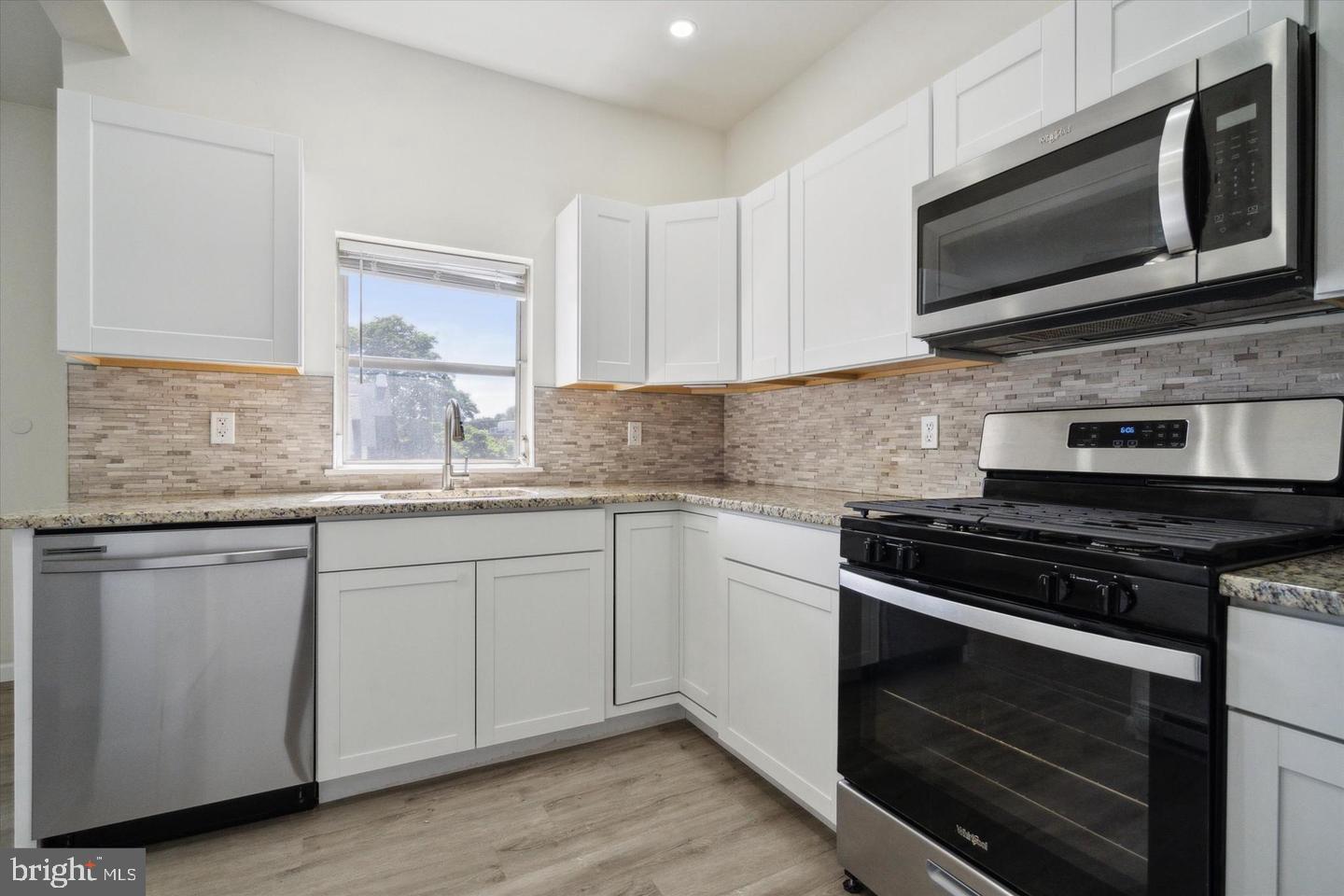 660 Loraine Street, Unit 2 Ardmore, PA 19003 - Photo 4 of 16 a kitchen with granite countertop cabinets stainless steel appliances and wooden floor