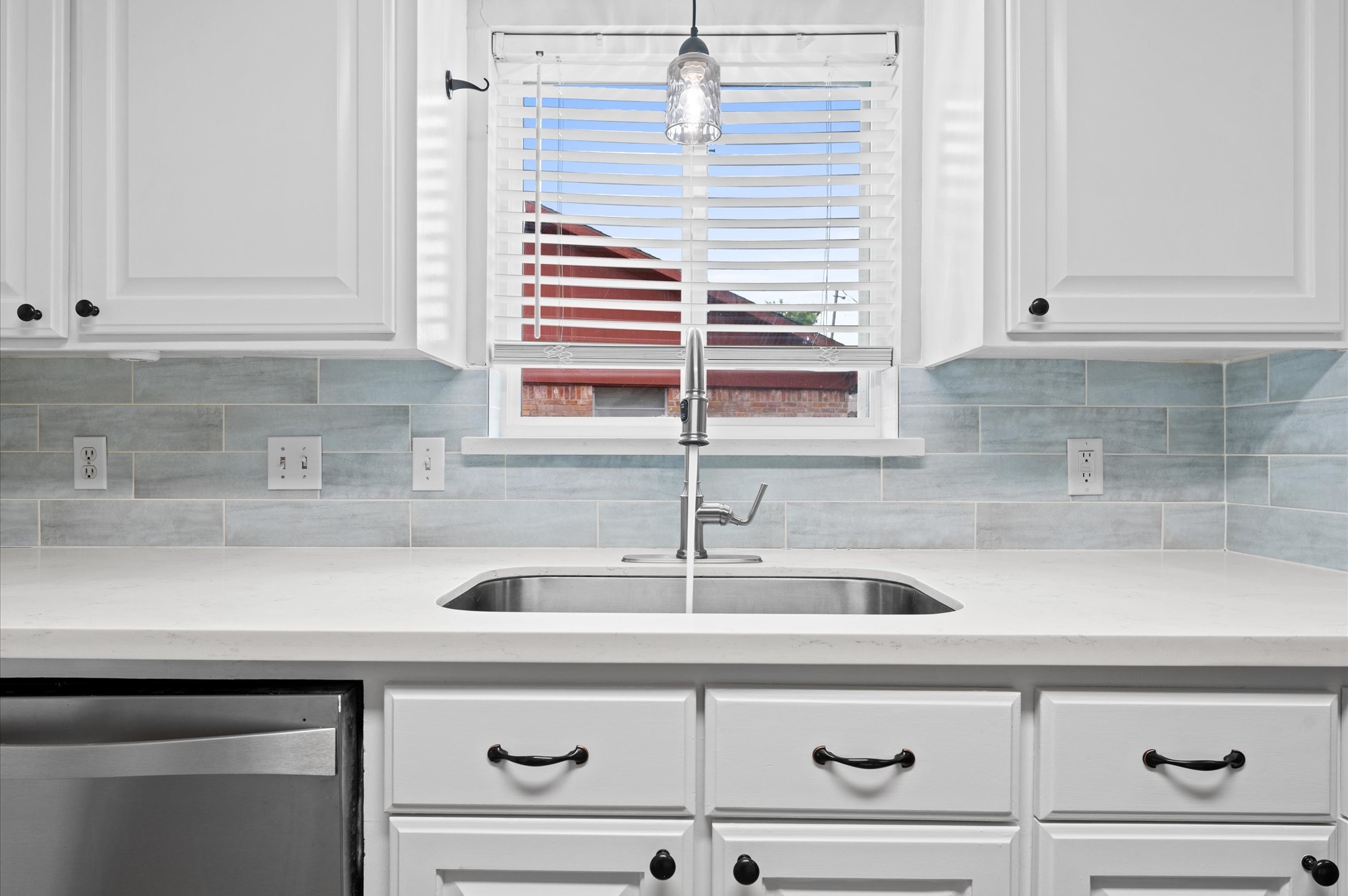 9407 Brooding Oak Circle Houston, TX 77096 - Photo 12 of 43 The kitchen window above the sink provides natural light, complemented by a stylish pendant light.