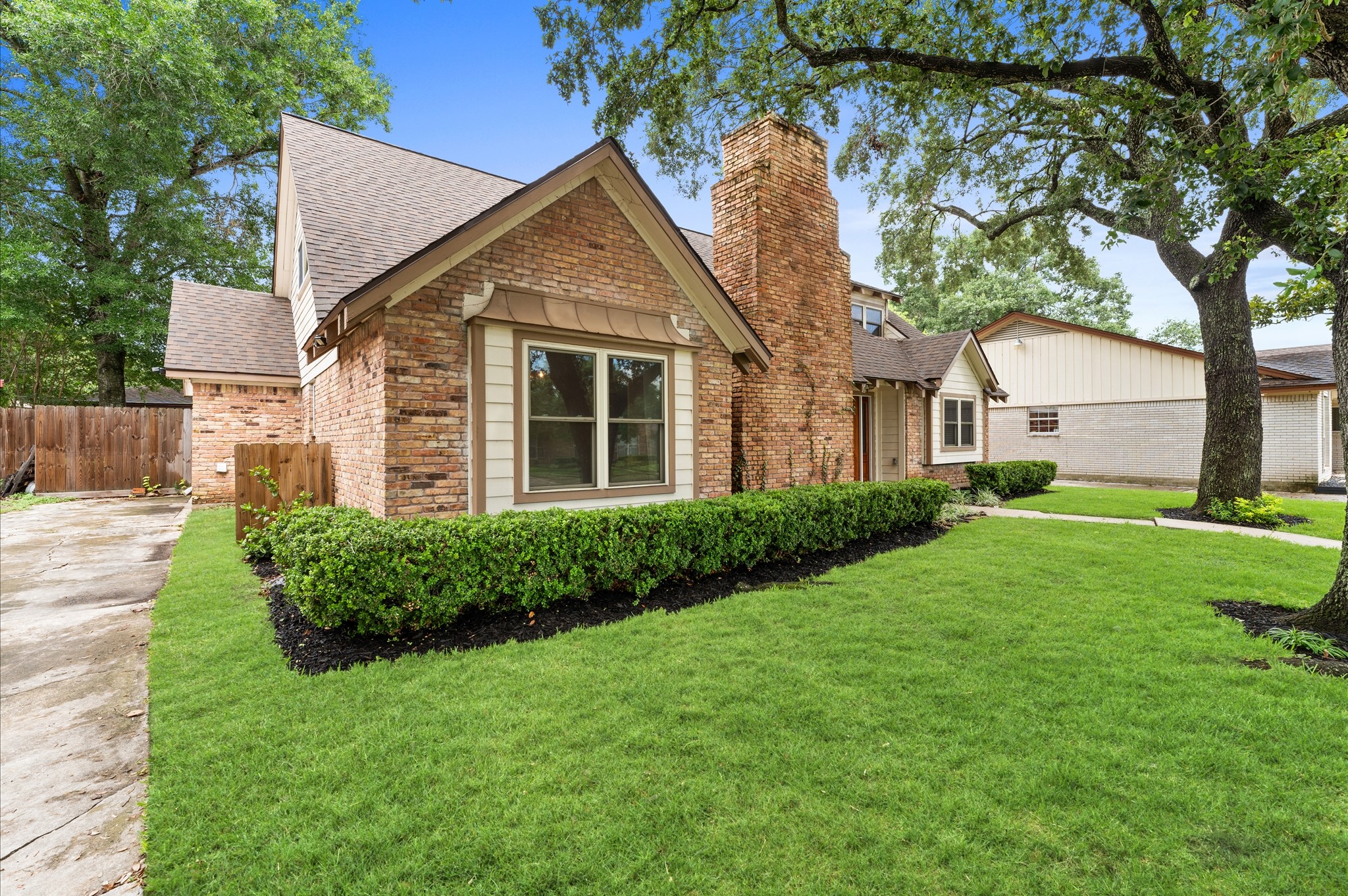 9407 Brooding Oak Circle Houston, TX 77096 - Photo 3 of 43 a view of a yard in front of a house with plants and large tree