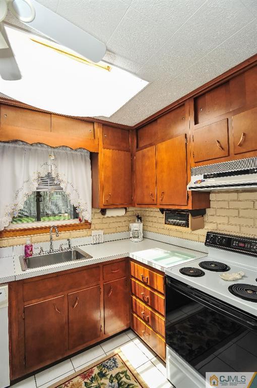 20 Roger Road Edison, NJ 08817 - Photo 11 of 25 a kitchen with stainless steel appliances granite countertop a stove a sink and a wooden cabinets