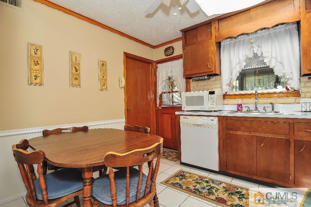 20 Roger Road Edison, NJ 08817 - Photo 13 of 25 a dining room with stainless steel appliances kitchen island granite countertop a table chairs and a refrigerator