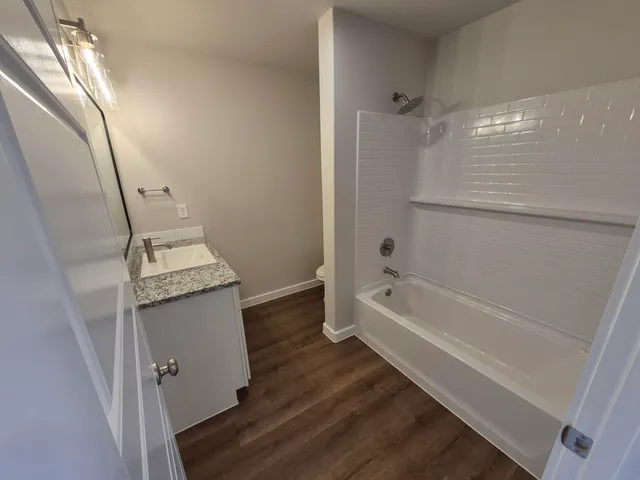 a bathroom with a tub a sink and a mirror