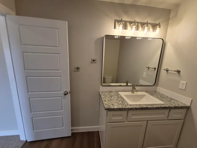 a bathroom with a granite countertop sink and mirror