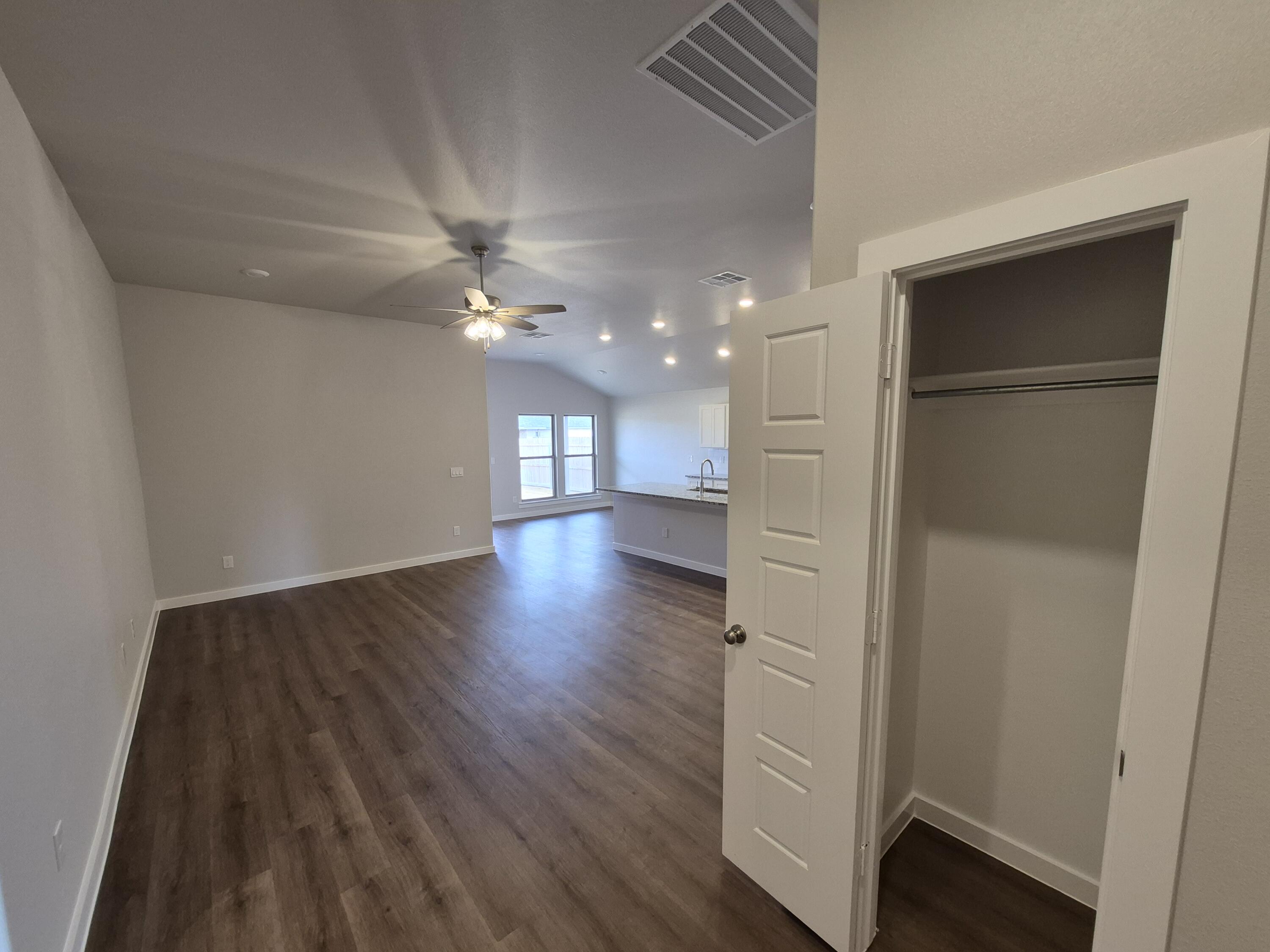 7008 14th Street Lubbock, TX 79416 - Photo 18 of 21 a view of an empty room with wooden floor and a ceiling fan