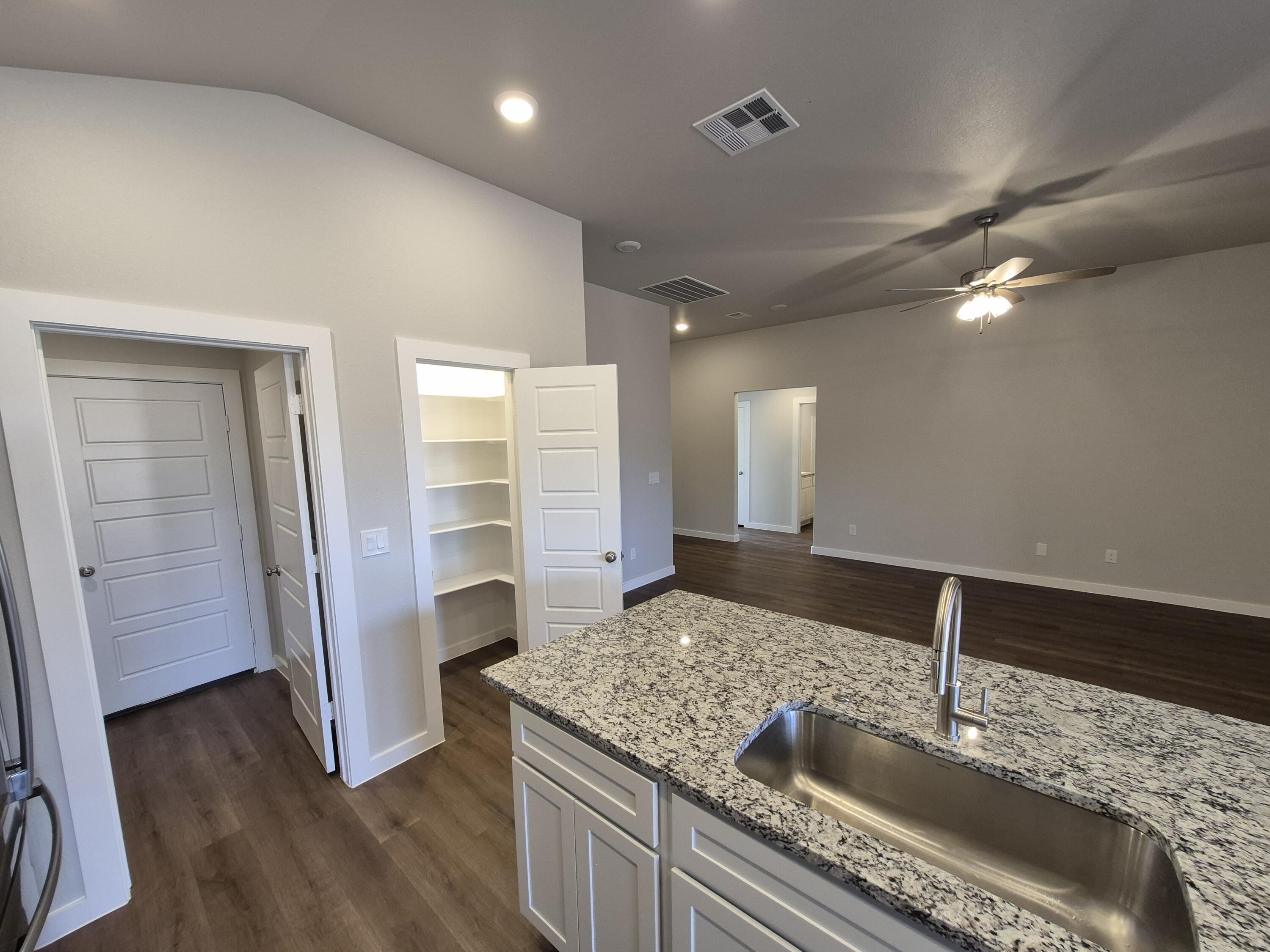 7008 14th Street Lubbock, TX 79416 - Photo 8 of 21 a kitchen with granite countertop a sink and refrigerator