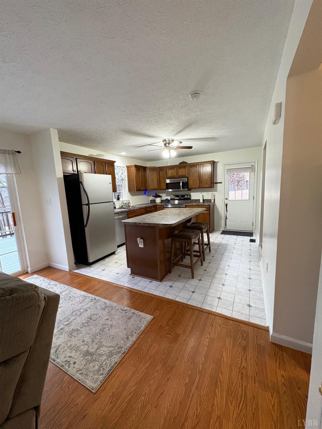 324 Ruth Drive Madison Heights, VA 24572 - Photo 23 of 31 Kitchen with new flooring and exit to side yard. Refrigerator, dishwasher, microwave and stove installed 11/25.