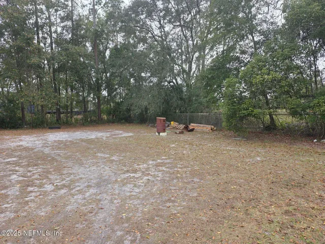 a backyard of a house with lots of green space and trampoline
