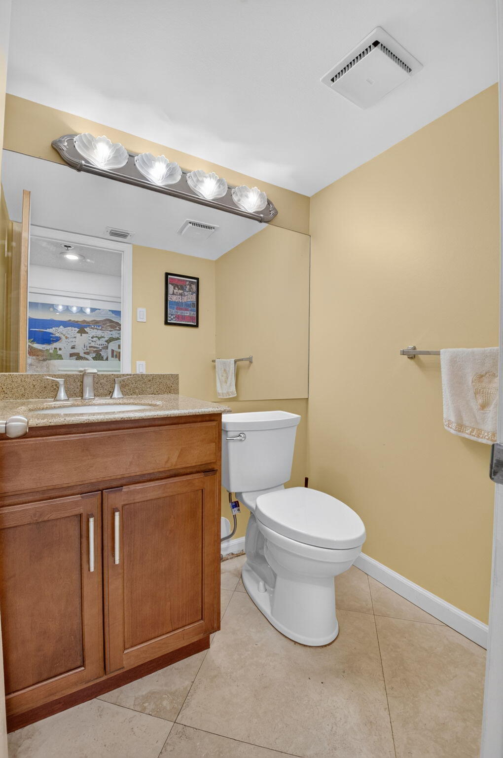 1401 South Ocean Boulevard, Unit 1060 Boca Raton, FL 33432 - Photo 14 of 46 a bathroom with a granite countertop toilet sink and mirror