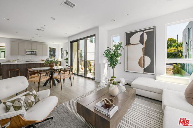a living room with furniture a dining table and a large window