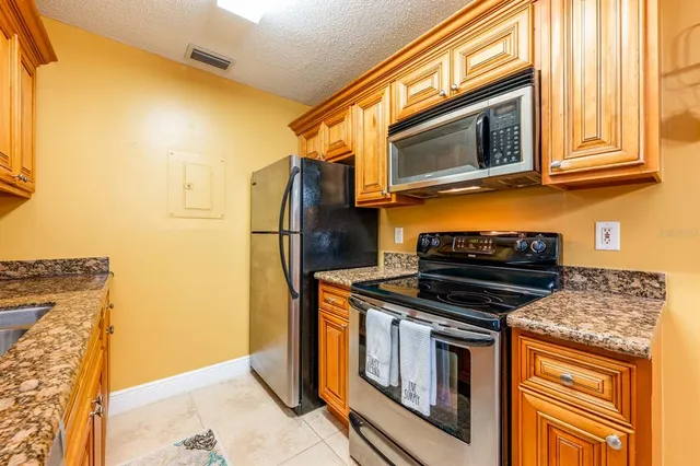 a kitchen with stainless steel appliances granite countertop a stove microwave and refrigerator