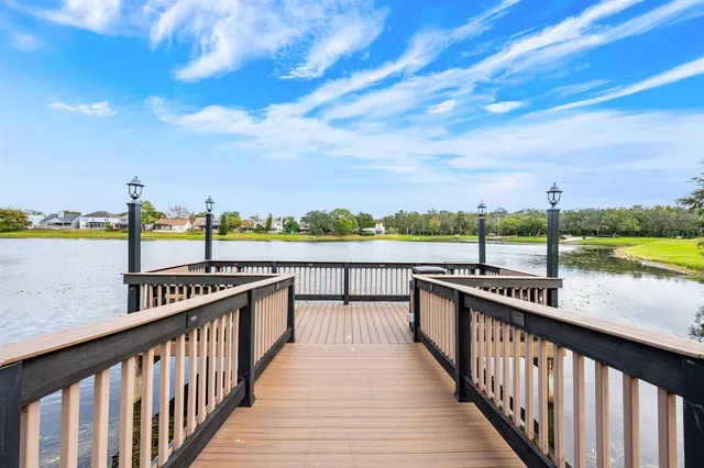 a view of a balcony with wooden floor & fence