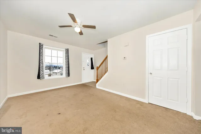 an empty room with windows and ceiling fan view