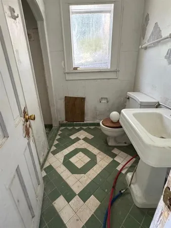 a bathroom with a toilet sink and mirror